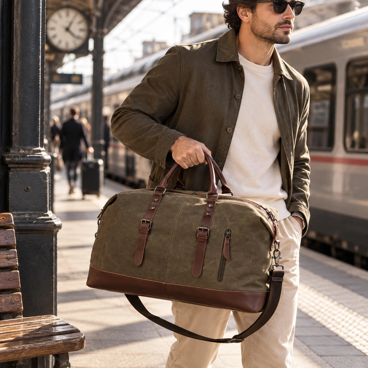 Homme portant un sac de voyage en toile kaki sur un quai de gare